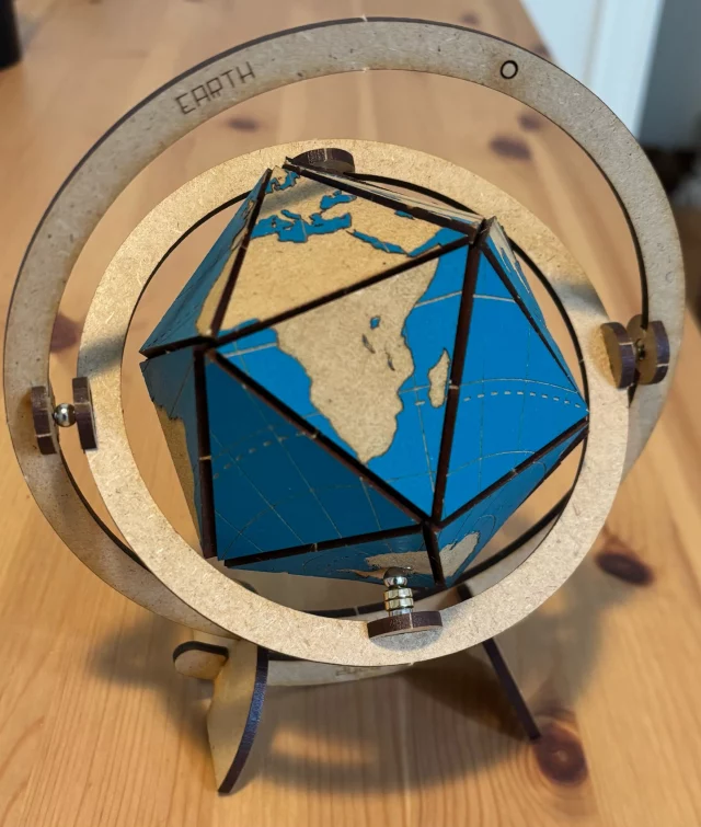 Vendredi, j’ai reçu un cadeau au nom pas très joli : " dymaxion map ". Il s’agit d’un grand nombre de pièces en bois, et de quelques aimants qu’il s’agit de découper et d’assembler pour former une espèce de globe terrestre en forme d’icosaèdre.
Le mode d’emploi n’est pas si facile que ça. Heureusement que j’ai déjà monté quelques meubles IKEA. J’étais fier de mon succès mais il m’a fallu un peu de temps !

Les 20 triangles équilatéraux peuvent aussi s’assembler en planisphère. La publicité affirme qu’on peut le faire de 43 3480 manières. Le vérifier est un joli exercice (que je n’ai pas fait !)

Merci aux généreux donateur !